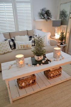 a living room filled with furniture and a christmas tree on top of a coffee table