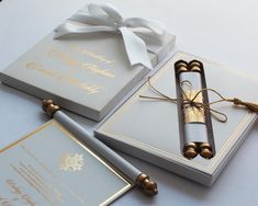 the wedding stationery is decorated with gold and silver decorations, such as a pen