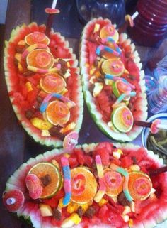 two watermelon boats filled with fruit on top of a table