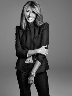 a woman posing for a black and white photo with her hands on her hips, smiling at the camera