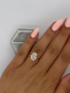 a woman's hand with pink manicured nails and a diamond ring