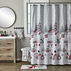 a shower curtain with snowmen and christmas trees on it, in a bathroom setting