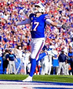 a football player is running on the field with his arms out and hands in the air