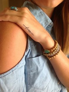 a woman's arm with a tattoo that says faith on it and two bracelets