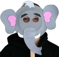 a paper plate elephant mask on top of a person's face with pink eyes