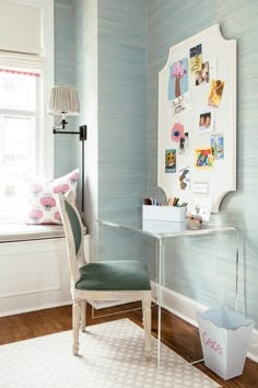 a chair sitting in front of a window next to a desk with a lamp on it