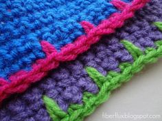 a crocheted blanket is laying on the table