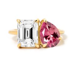 an engagement ring with two pink and white stones on the sides, in yellow gold