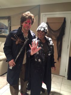 two people dressed up as zombies and one is holding their hand out for the camera