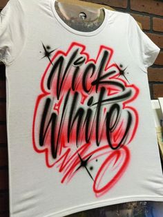 a white t - shirt with black and red spray paint on it that says kickin'whine