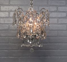 a crystal chandelier hanging from a brick wall