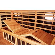 a wooden bench sitting on top of a hard wood floor next to a wall filled with windows