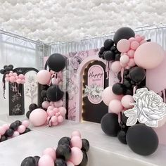 balloons and streamers are on display at a birthday party in pink, black and white