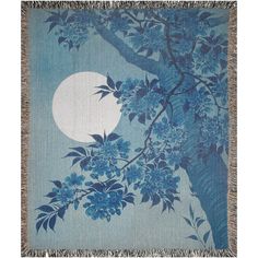 a blue and white blanket with flowers on it, in front of a full moon