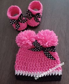 a pair of pink and white crocheted baby booties with black polka dots