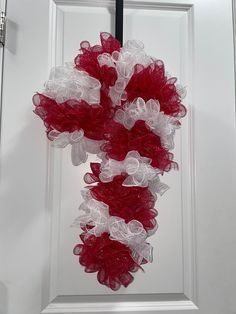 a red and white wreath hanging on the front door