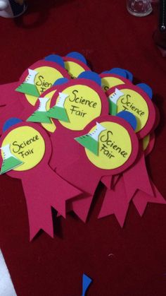 some sort of science fair stickers on a red table with other items in the background