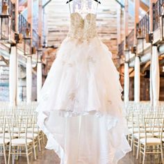 a wedding dress hanging from a rack in a building