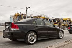 a black car parked in front of a construction site