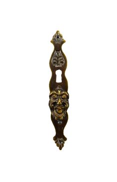 an ornate door handle with a face on it