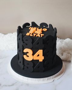 a black and orange cake with numbers on it