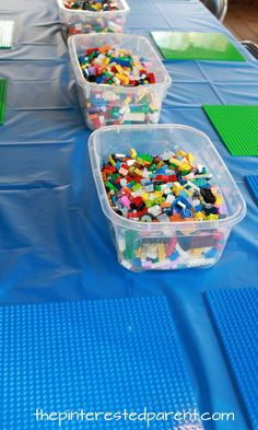 plastic containers filled with legos sitting on top of a blue tablecloth covered table