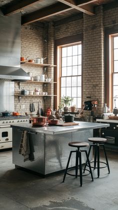 an industrial style kitchen with brick walls and stainless steel island countertop, stools, and open shelving