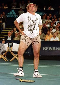 a man standing on top of a tennis court holding a racquet in his hand