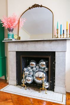 a fire place with candles and decorations on the mantel in front of it that says diy disco ball fireplace