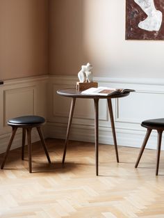 two small wooden tables sitting next to each other on top of a hard wood floor