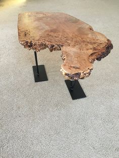 a wooden table sitting on top of black metal legs