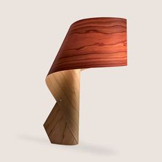 a wooden table lamp with a red shade on it