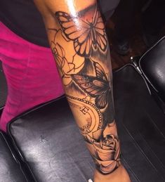 a woman's leg with a butterfly and flowers tattoo on her left calf sleeve