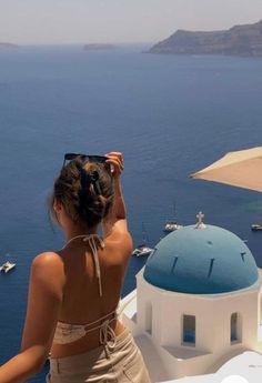 a woman standing on top of a building next to the ocean