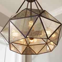 a chandelier hanging from the ceiling in a room with white walls and windows