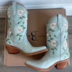 a pair of blue cowboy boots sitting on top of a box