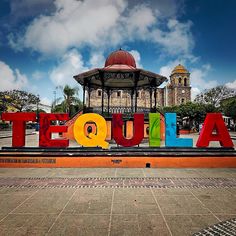 there is a sign that says tequila in front of a building with a dome on top