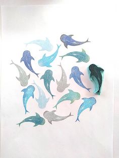 a group of blue and silver dolphins on white paper