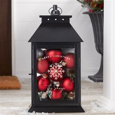 a black lantern with christmas decorations on it