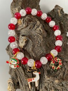 Beautiful handmade Holiday Christmas Beaded Bracelet with Clear Crackle Beads and Solid Red Beads. Charms include Snowman, Reindeer & Christmas Wreath. Charms are attached to split rings (like your car keys) so they can't fall off Faceted Beads Dangle Bracelets As Gift, Holiday Gift Bracelets With Round Beads, Holiday Bracelets With Round Beads, Handmade Adjustable Beaded Bracelets For Holidays, Christmas Holiday Bracelets With Round Beads, Christmas Gift Bracelets With Colorful Beads, Festive Christmas Bracelets With Round Beads, Adjustable Christmas Beaded Bracelets, Colorful Beads Christmas Gift Bracelets