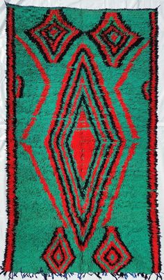 a green and red area rug with fringes