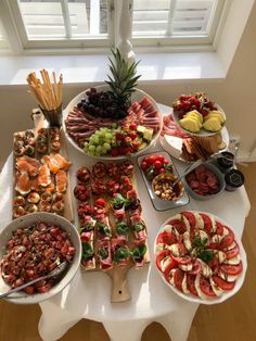 a table topped with lots of different types of fruit and veggie platters