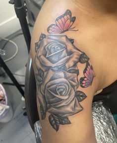 a woman's arm with roses and butterflies on it