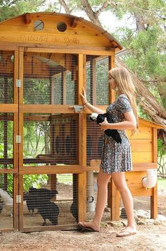 a woman standing in front of a chicken coop