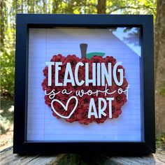 a shadow box frame with the words teaching is a work of art in white and red