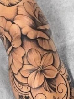 an arm with flowers on it and a bird sitting on top of the flower in the middle