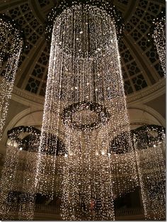 a large chandelier with lights hanging from it's ceiling in a building