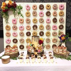 a table topped with lots of donuts and desserts