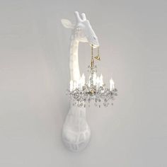 a giraffe is holding a chandelier in its mouth