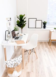 a white desk topped with a laptop computer sitting on top of a hard wood floor